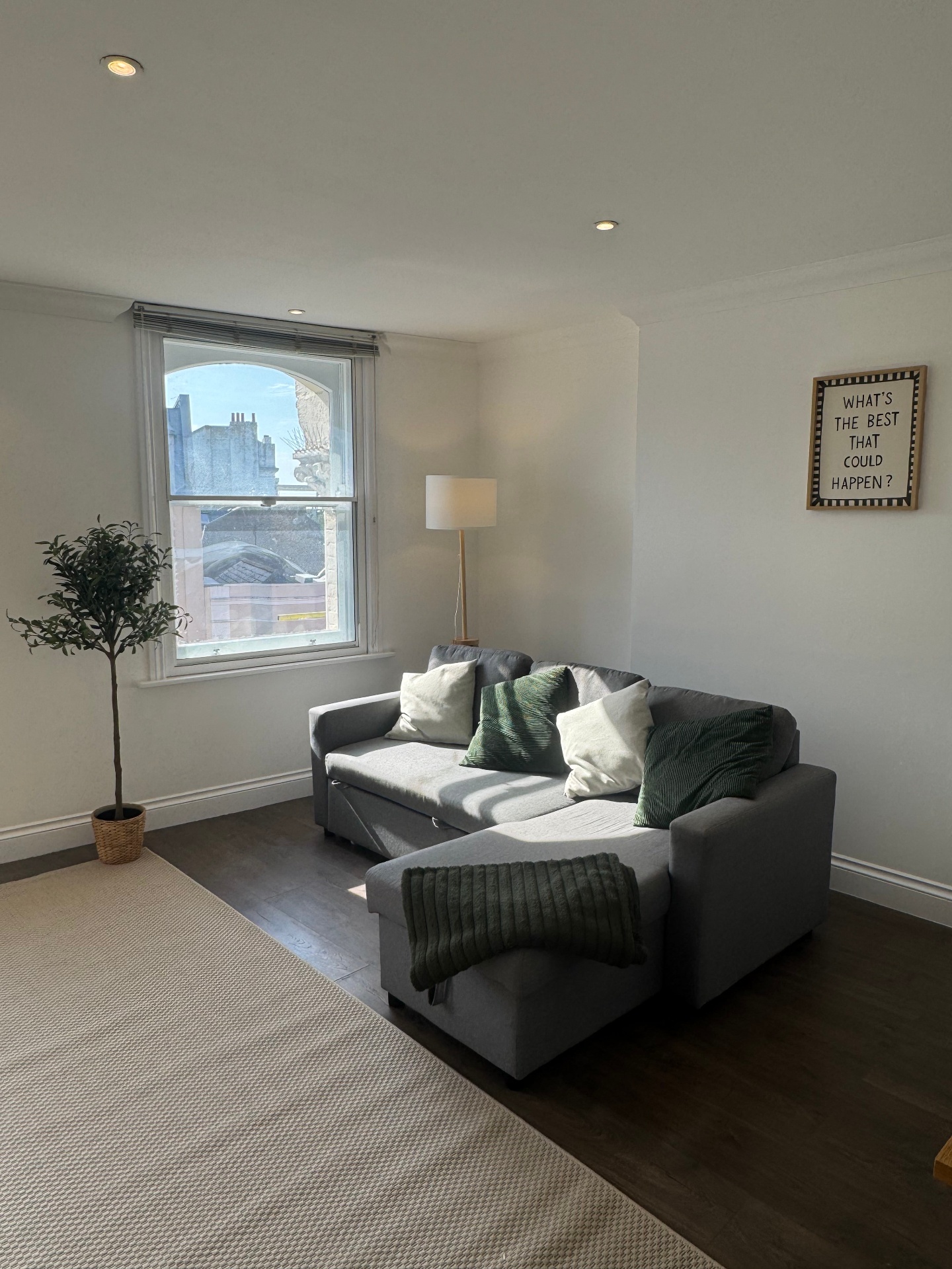 Living room with grey corner sofa and bay window